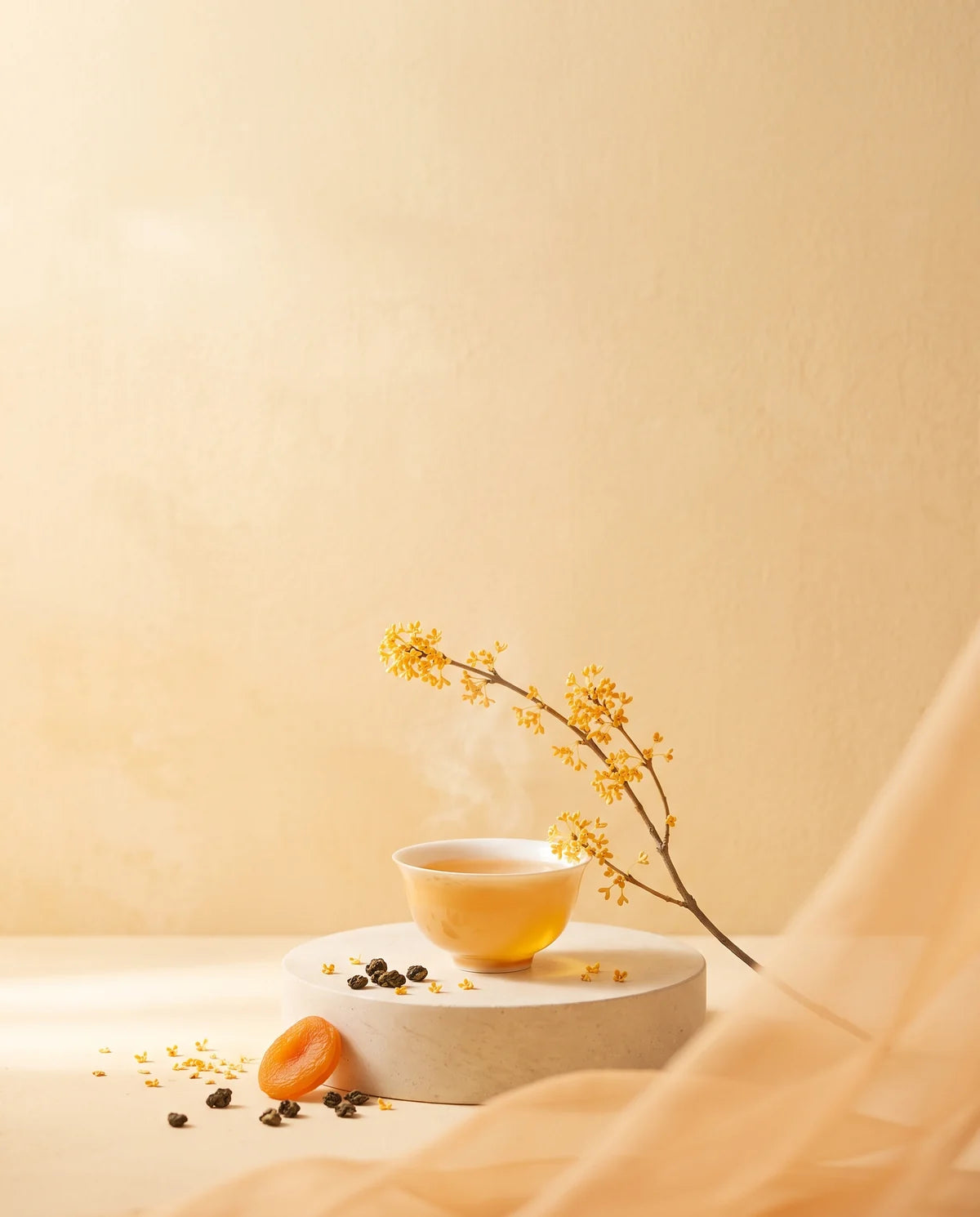 A cup of golden oolong on a pale plinth, osmanthus blossom arcing above it