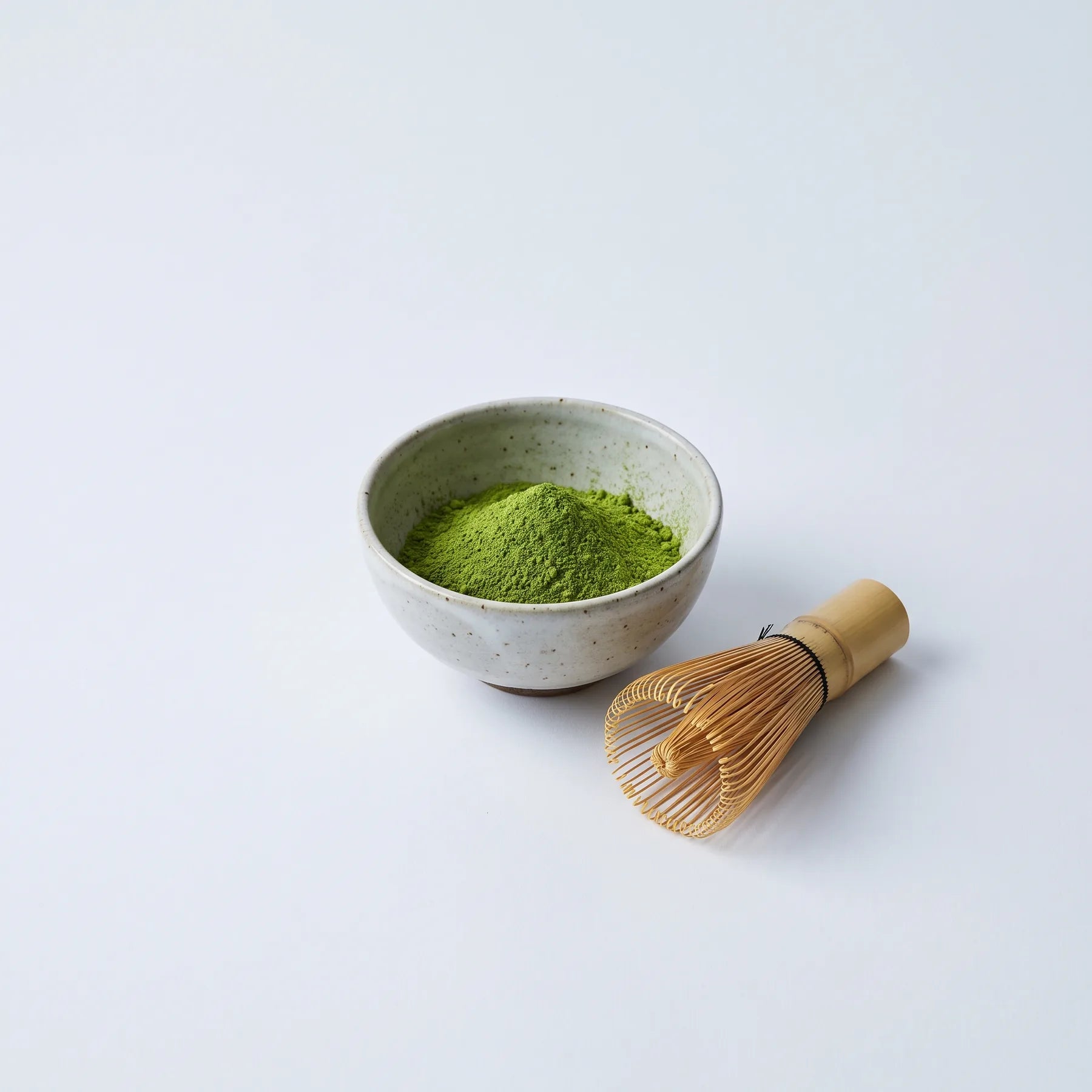 Kaori powder in a stoneware bowl beside a bamboo whisk