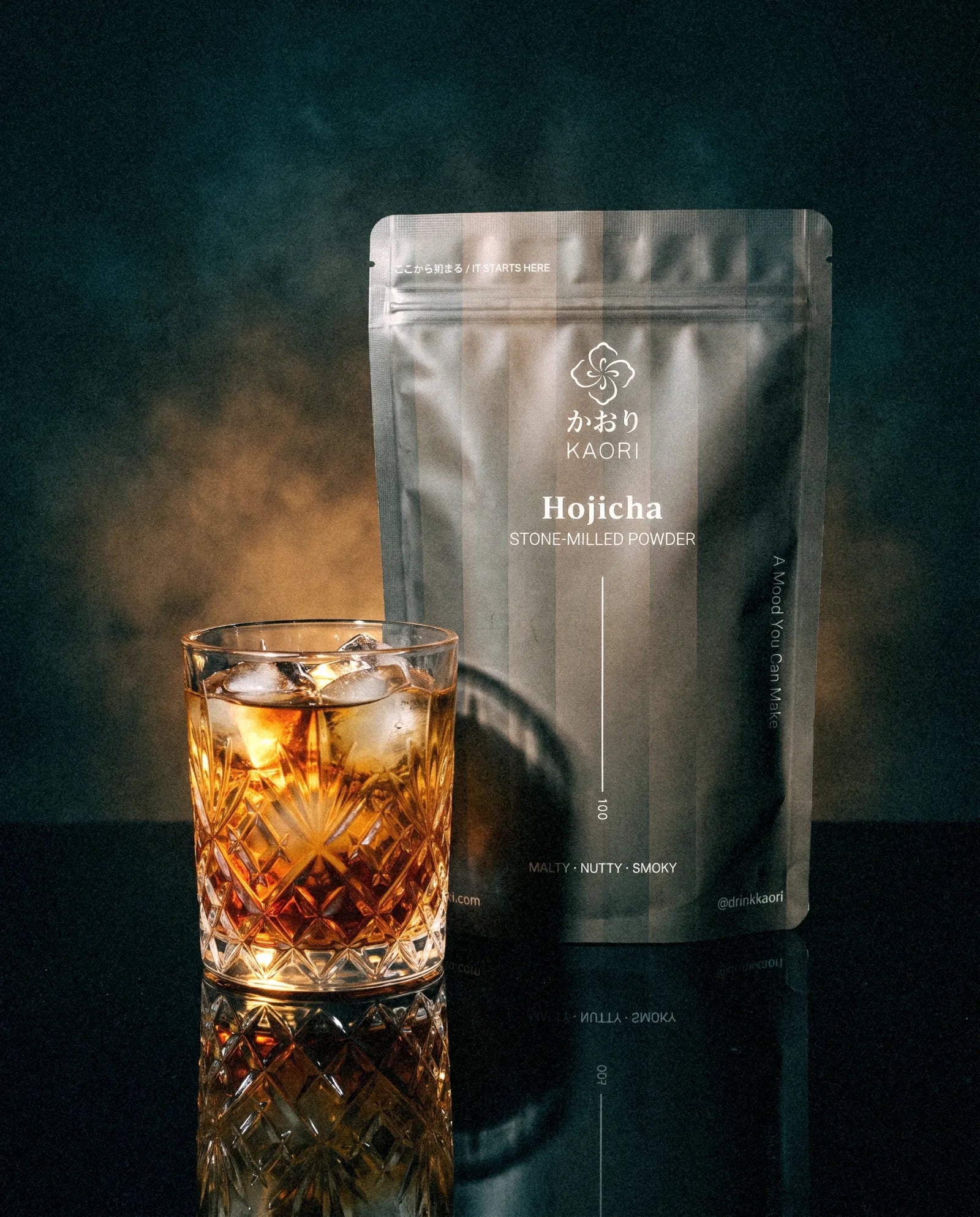 Hojicha, the pouch beside an iced crystal tumbler